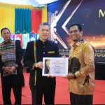 Rektor USK Prof Dr Ir Marwan menyerahkan penghargaan mitra perbankan terbaik kepada Institutional Banking and Government Relationship Deputy BSI Aceh, Saiful Musadir. (Foto: For Infoaceh.net)