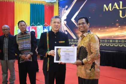 Rektor USK Prof Dr Ir Marwan menyerahkan penghargaan mitra perbankan terbaik kepada Institutional Banking and Government Relationship Deputy BSI Aceh, Saiful Musadir. (Foto: For Infoaceh.net)