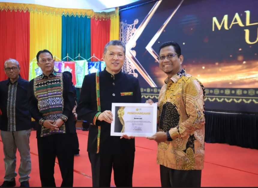 Rektor USK Prof Dr Ir Marwan menyerahkan penghargaan mitra perbankan terbaik kepada Institutional Banking and Government Relationship Deputy BSI Aceh, Saiful Musadir. (Foto: For Infoaceh.net)