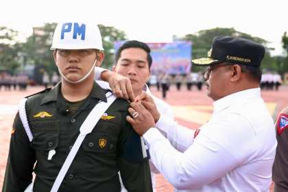 Pj Gubernur Aceh Safrizal ZA menyematkan pita kepada personel sebagai peserta Operasi Lilin Seulawah tahun 2024 saat apel gelar pasukan pengamanan Natal 2024 dan Tahun Baru 2025, di Lapangan Mapolda Aceh, Jum'at (20/12). (Foto: For Infoaceh.net)