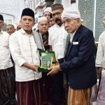 Ketua JATMAN Provinsi Aceh Tgk H Syukri Daud Pango menyerahkan plakat ucapan selamat kepada Abuya Syeikh H Amran Waly Al-Khalidy sebagai Wali Agama Aceh di Masjid Raya Baiturrahman Banda Aceh, Ahad malam (22/12). (Foto: Dok. Infoaceh.net)