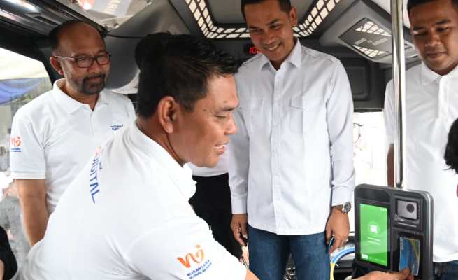 Bupati Aceh Besar Syech Muharram Idris menempelkan kartu Trans Koetaradja dalam acara peluncuran aplikasi Trans Koetaradja di Terminal Tipe A Batoh, Banda Aceh, Ahad (4/5)