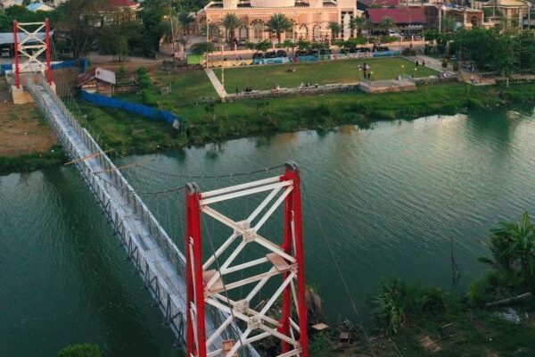 Jembatan gantung yang menghubungkan Gampong Lambhuk Kecamatan Ulee Kareng dan Gampong Lamseupeung Kecamatan Lueng Bata, Banda Aceh dengan latar belakang Masjid Haji Keuchik Leumiek. (Foto: Ist)