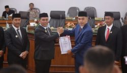 Bupati Aceh Besar Muharram Idris menyerahkan rancangan qanun perubahan APBK Aceh Besar tahun 2025 pada rapat paripurna DPRK Aceh Besar di Gedung DPRK setempat, Rabu (25/9).