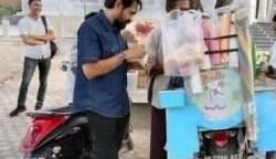 Gubernur Aceh Muzakir Manaf atau Mualem saat jajan es krim di depan sebuah masjid di Aceh yang penjualnya menggunakan sepeda motor berplat BK. (Foto: Ist)