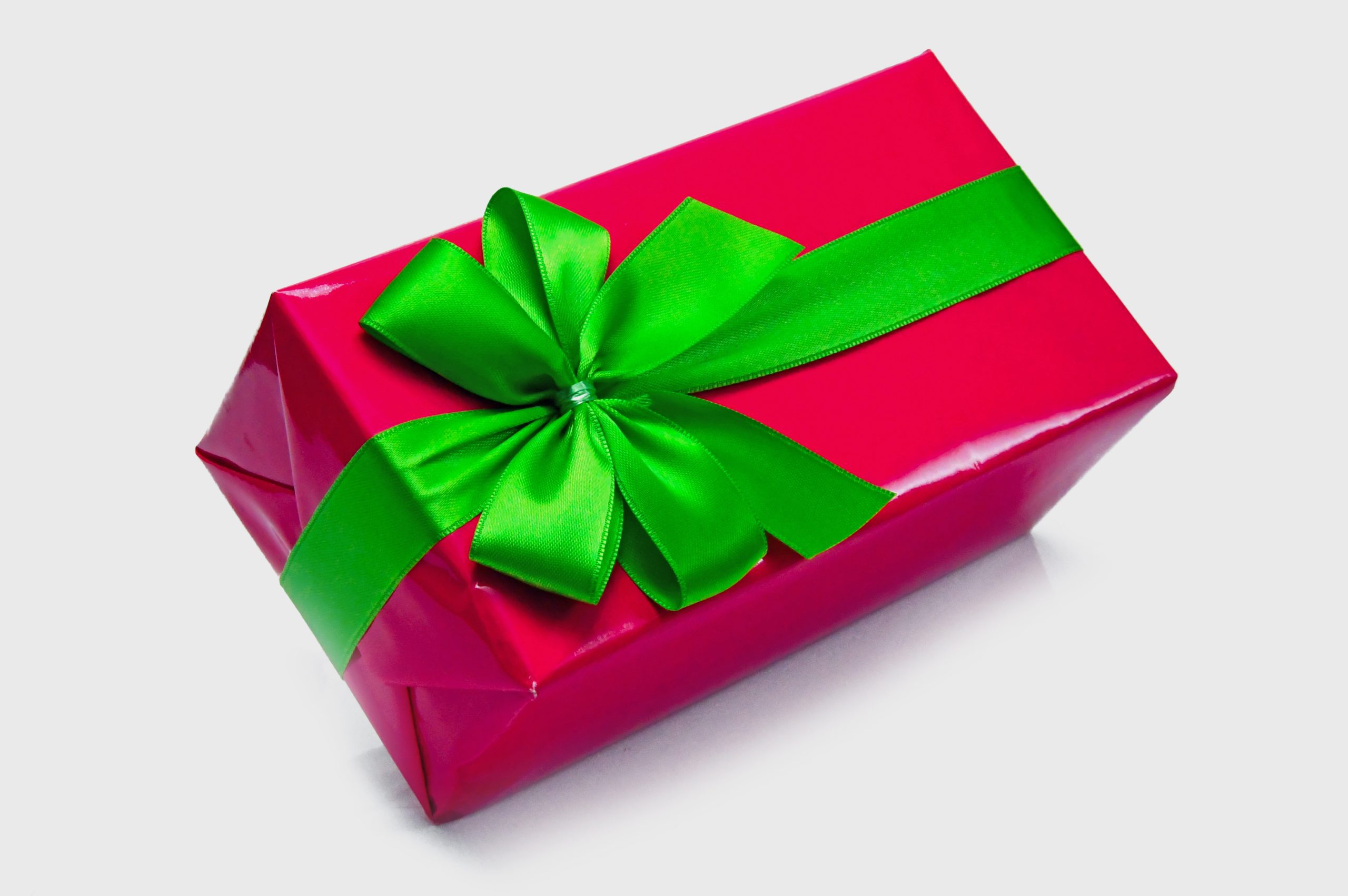 Red gift box with green ribbon on white background.
