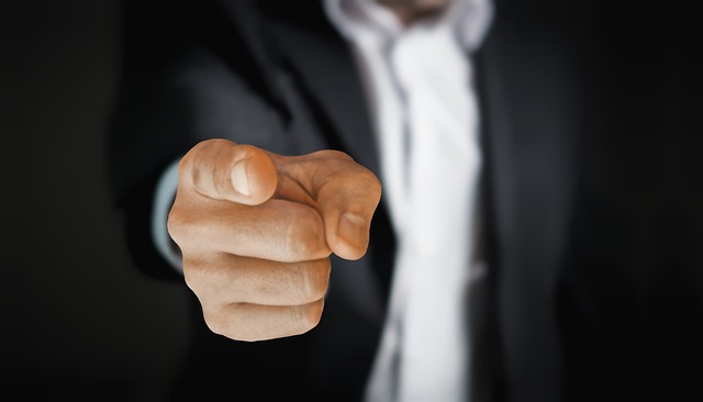 Man in suit pointing finger directly at the camera