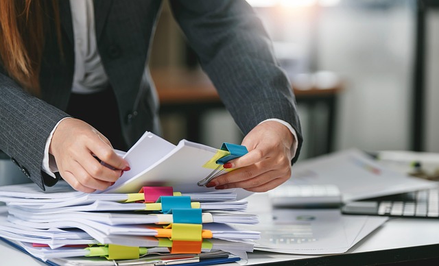 Office worker organizes documents with colorful sticky notes