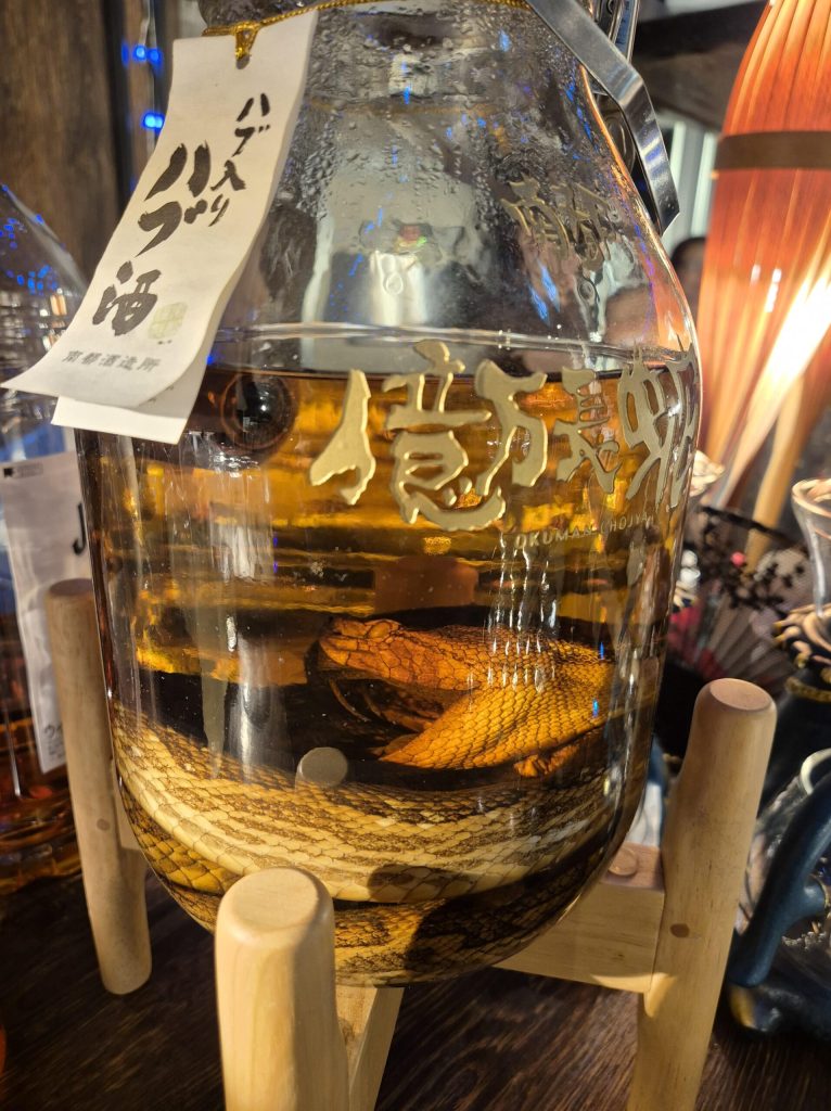 Large glass bottle of awamori spirit with a snake inside, traditional Okinawan alcohol.