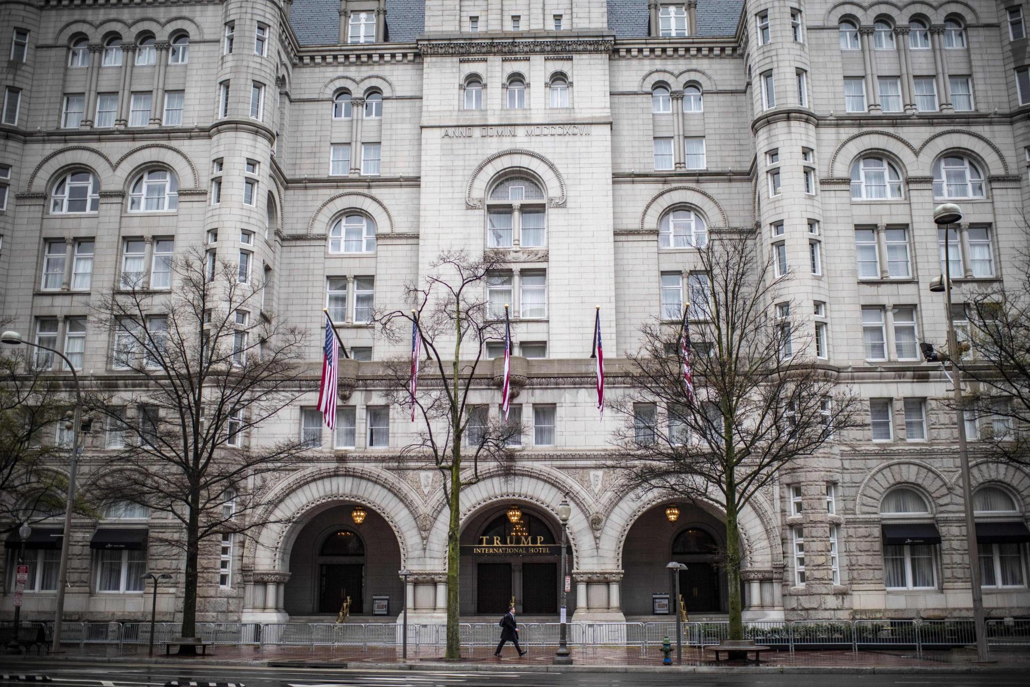 A lone pedestrian walks by the Trump hotel in downtown Washington, D.C. on March 25, 2020. (Photo by ERIC BARADAT/AFP via Getty Images)