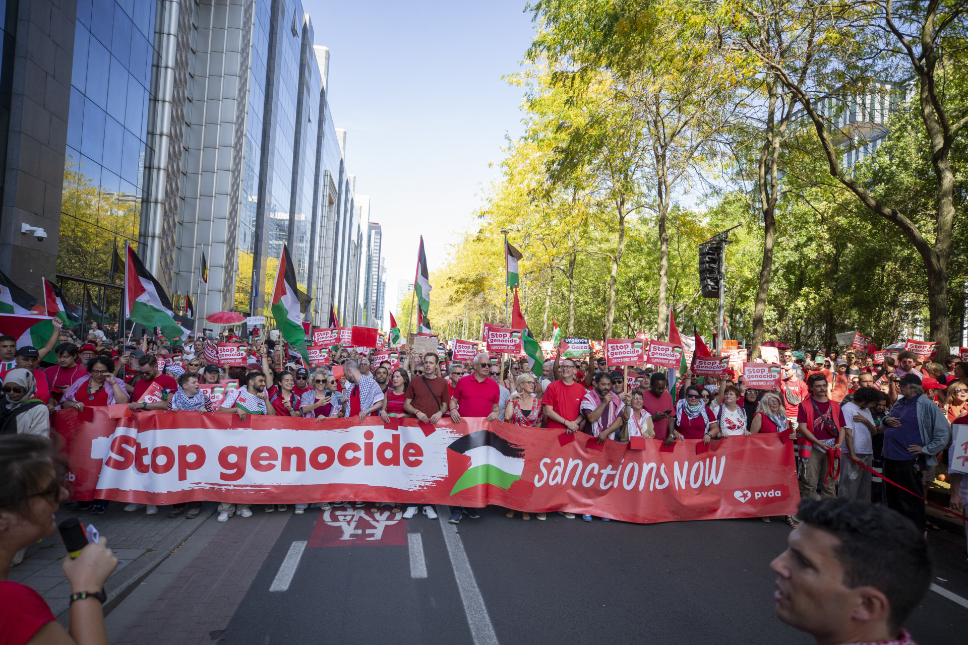Protesters carry a banner reading "Stop genocide, sanctions now" during a pro-Palestinian rally in Brussels, Belgium on September 7, 2025. More than 200,000 people filled the streets of the Belgian capital to denounce Israel's actions in Gaza. (Photo by WAHAJ BANI MOUFLEH/Middle East Images/AFP via Getty Images)
