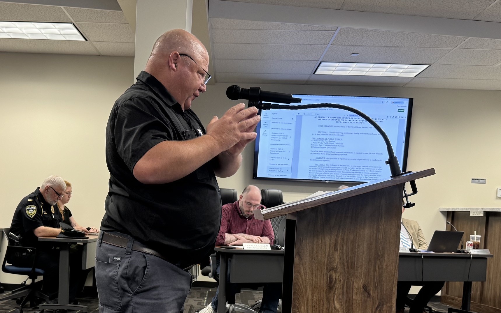 man standing at a podium gesturing