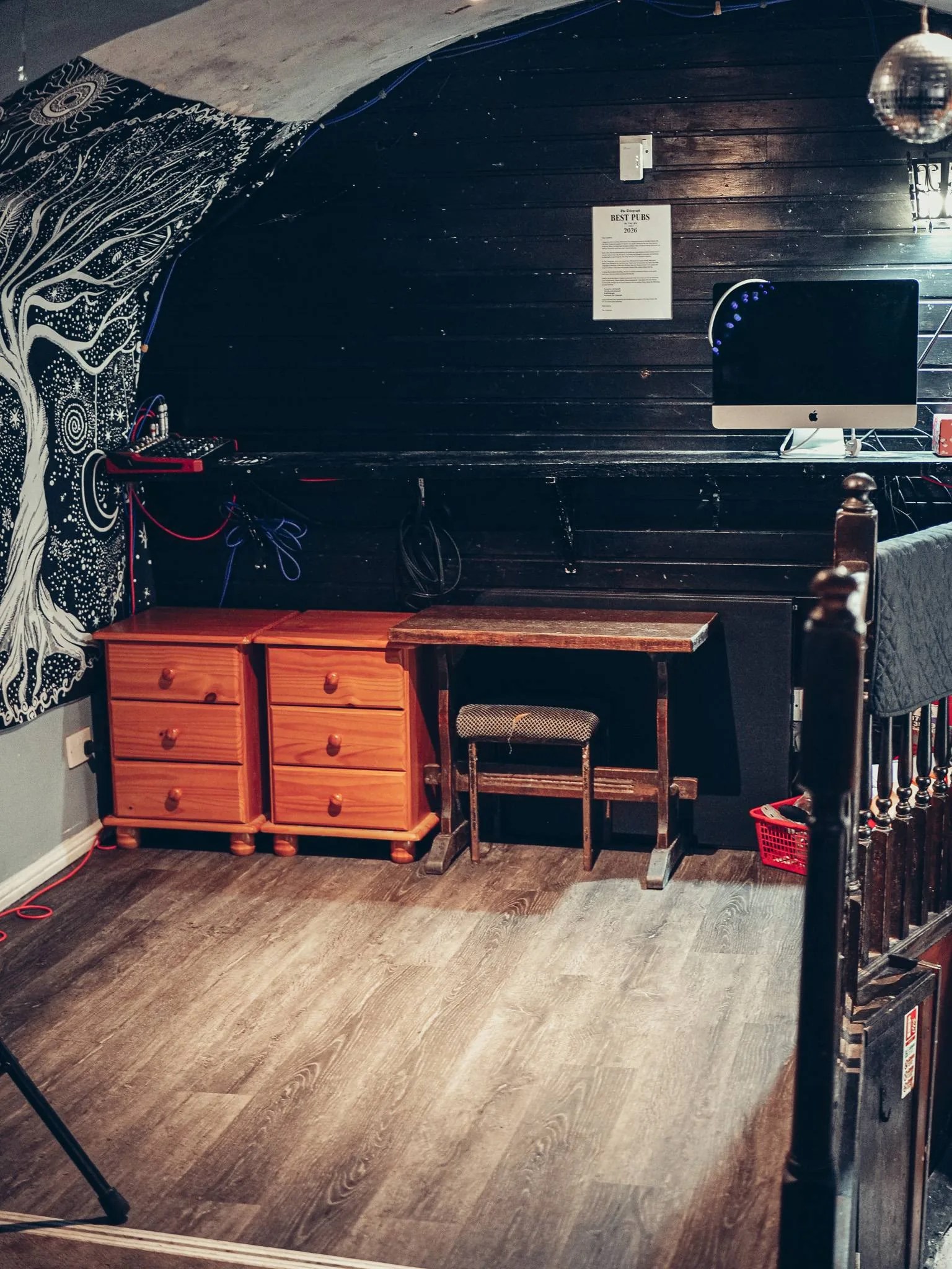 Recoin sombre du Settle Inn, a Stirling : un bureau de bois, une chaise et une decoration murale, loin de l'image d'un pub de centre-ville moderne.
