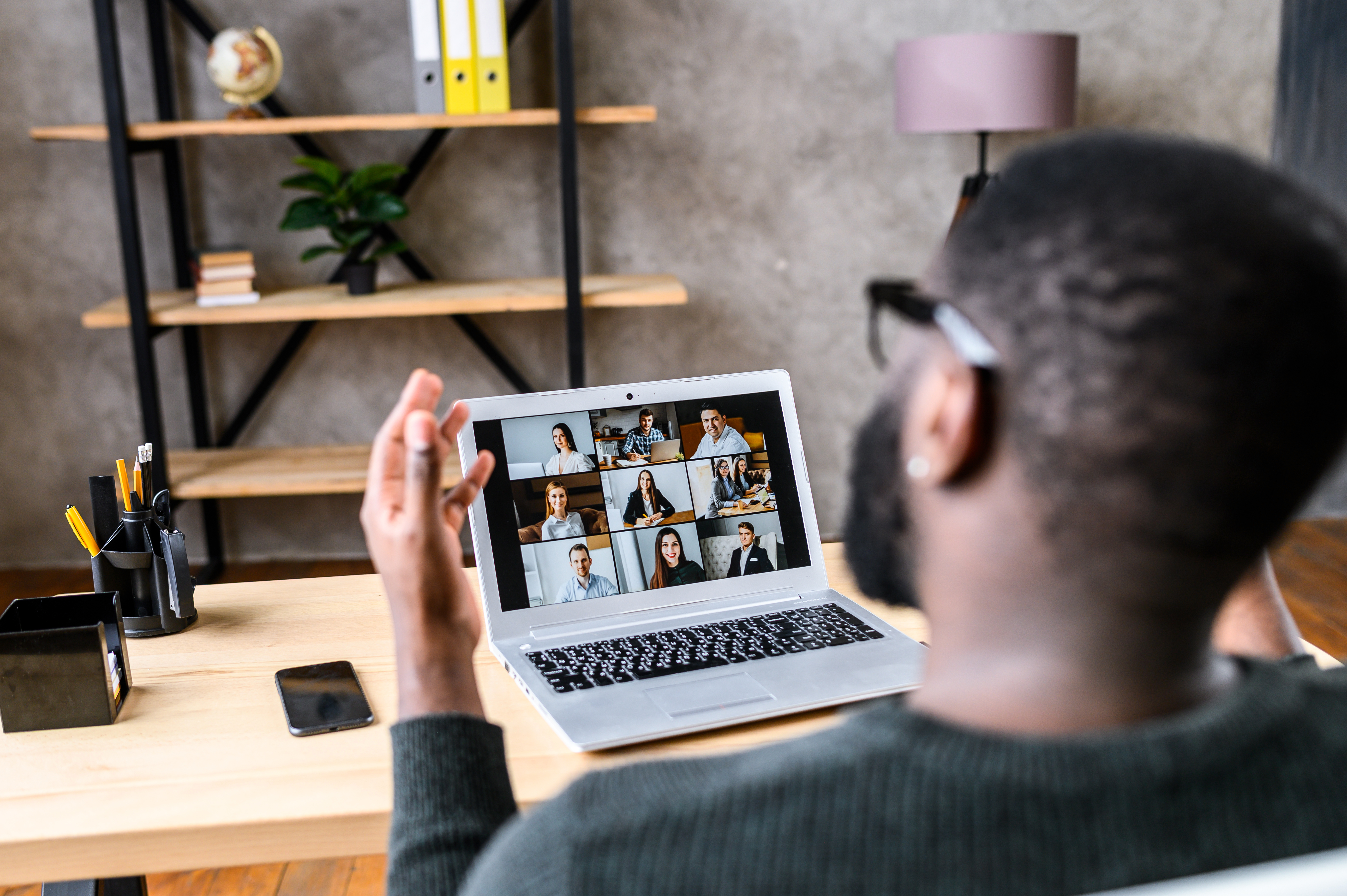 A guy talking online with employees via video call