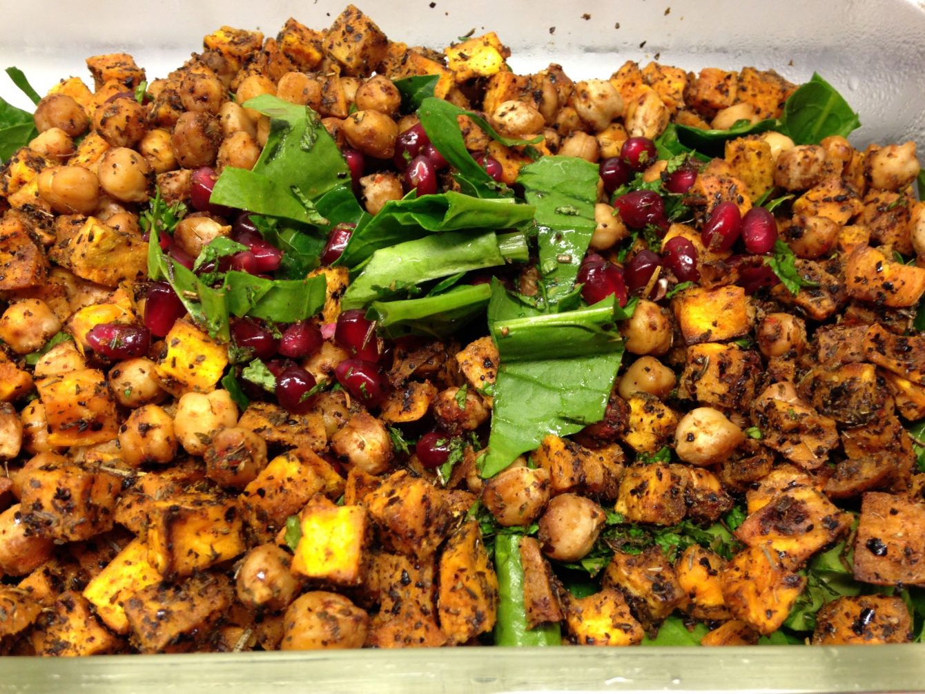 Salat aus gerösteten Kichererbsen und Süßkartoffeln mit Spinat, Granatapfelkernen und Tahini-Dressing