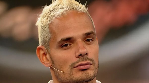 Federico Mastrostefano con capelli biondo platino e microfono auricolare durante una puntata di Uomini e Donne.