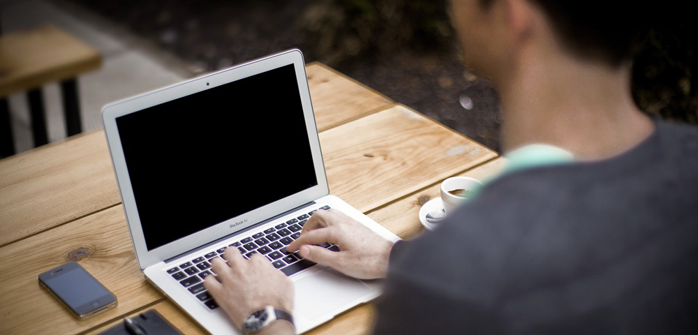 Many typing on laptop computer