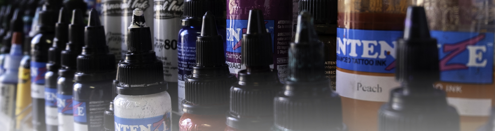closeup photo of tattoo ink bottles on a shelf