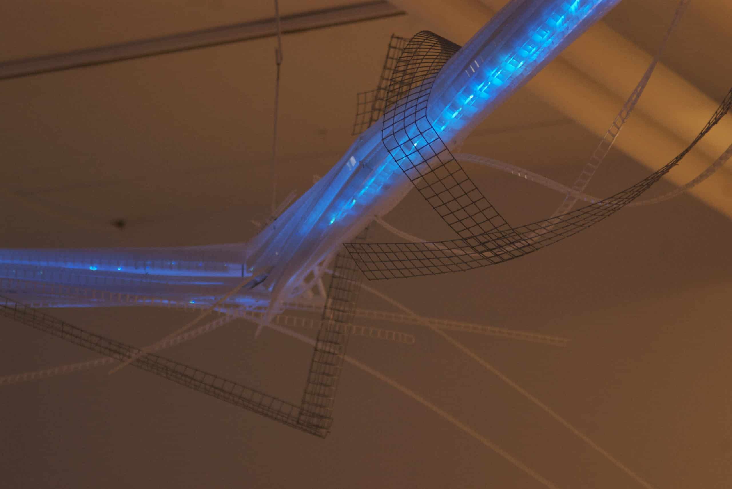 22-foot-long pendant LED light sculpture, changing colours.  LED lights run through three acrylic tubes joined with heavy gauge wire, wrapped with strips of steel mesh and polycarbonate.  stunning; completely original.