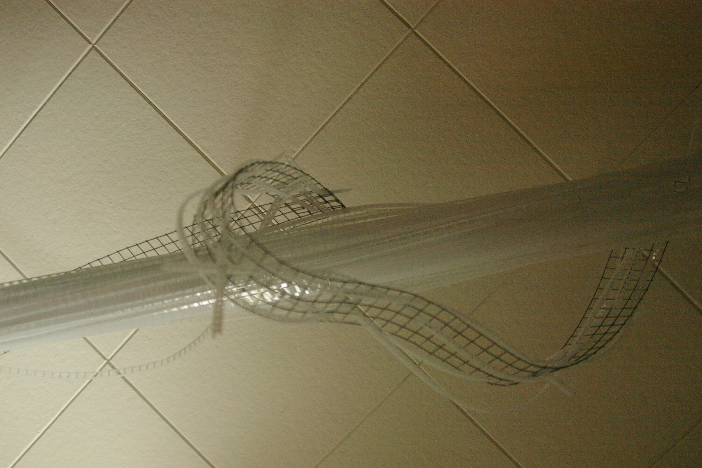 22-foot-long pendant LED light sculpture, changing colours.  LED lights run through three acrylic tubes joined with heavy gauge wire, wrapped with strips of steel mesh and polycarbonate.  stunning; completely original.