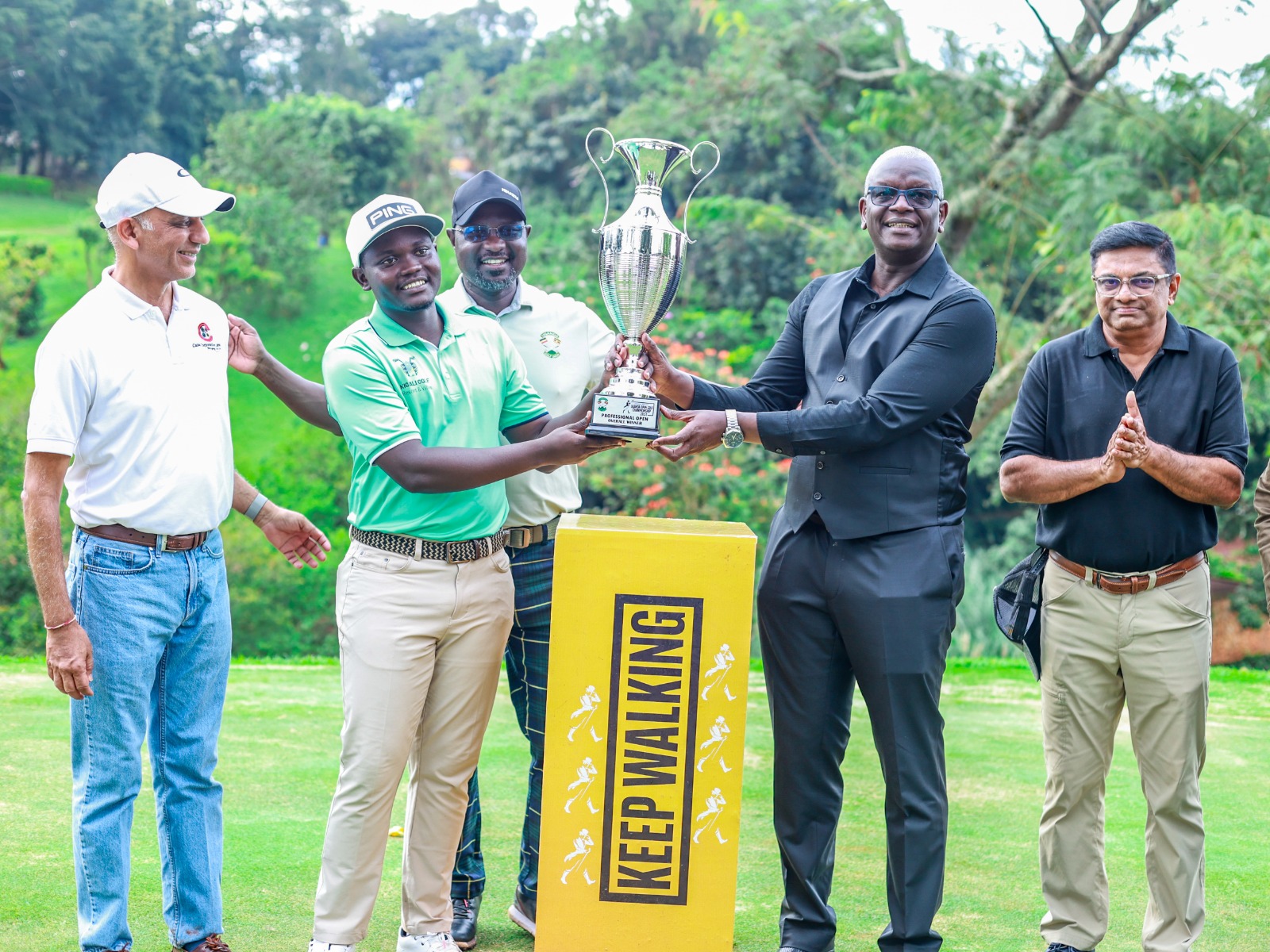 L-R Professional Open Winner Celestine Nsanzuwera receiving his trophy on the green by the Uganda Breweries outgoing MD Andrew Kilonzo.