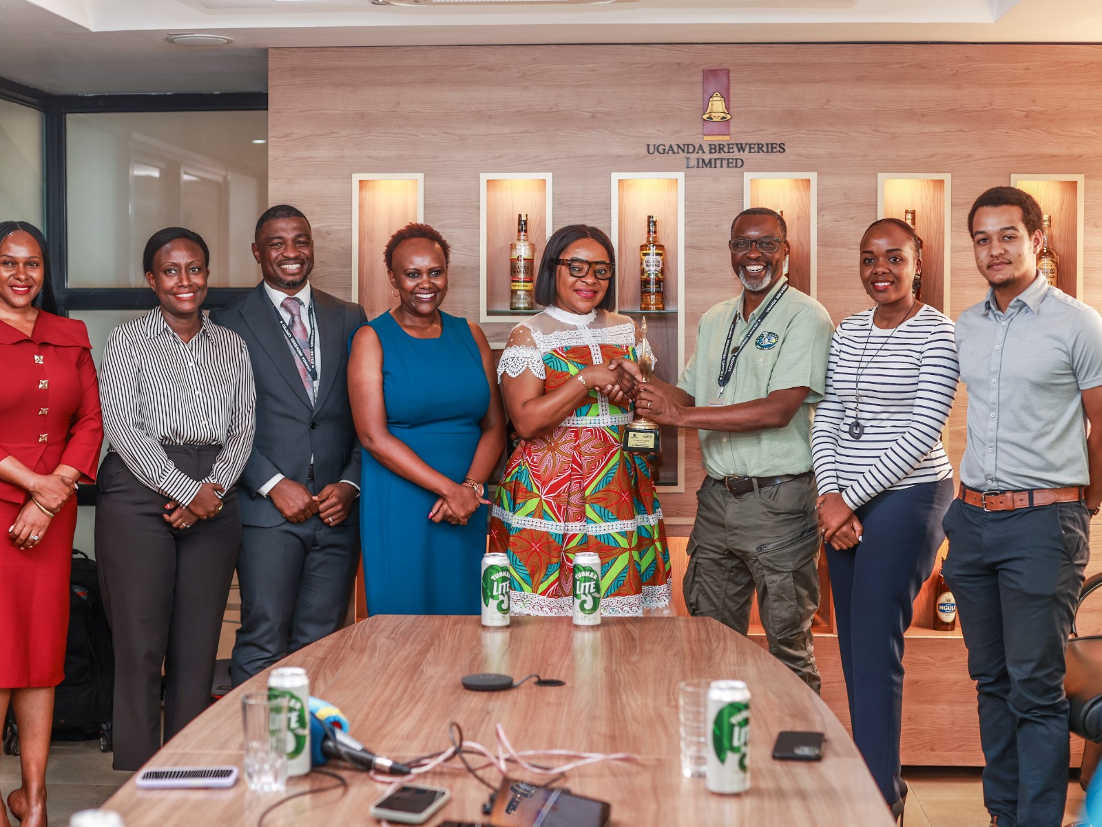 UBL Managing Director Felicite Nson (4R) receives the award from Tusker Lite Mt. Rwenzori Marathon Team Lead Amos Wekesa (3R), as other stakeholders look on.