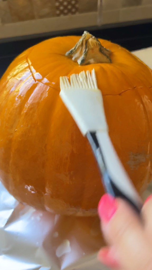 Stuffed pumpkin brushed with olive oil before roasting