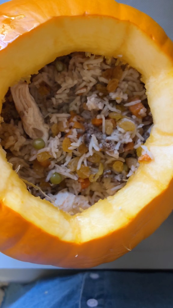 Whole pumpkin being filled with basmati rice and ground beef