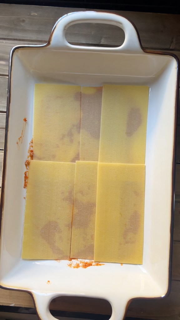 No-boil lasagna noodles arranged over slow-cooked meat sauce