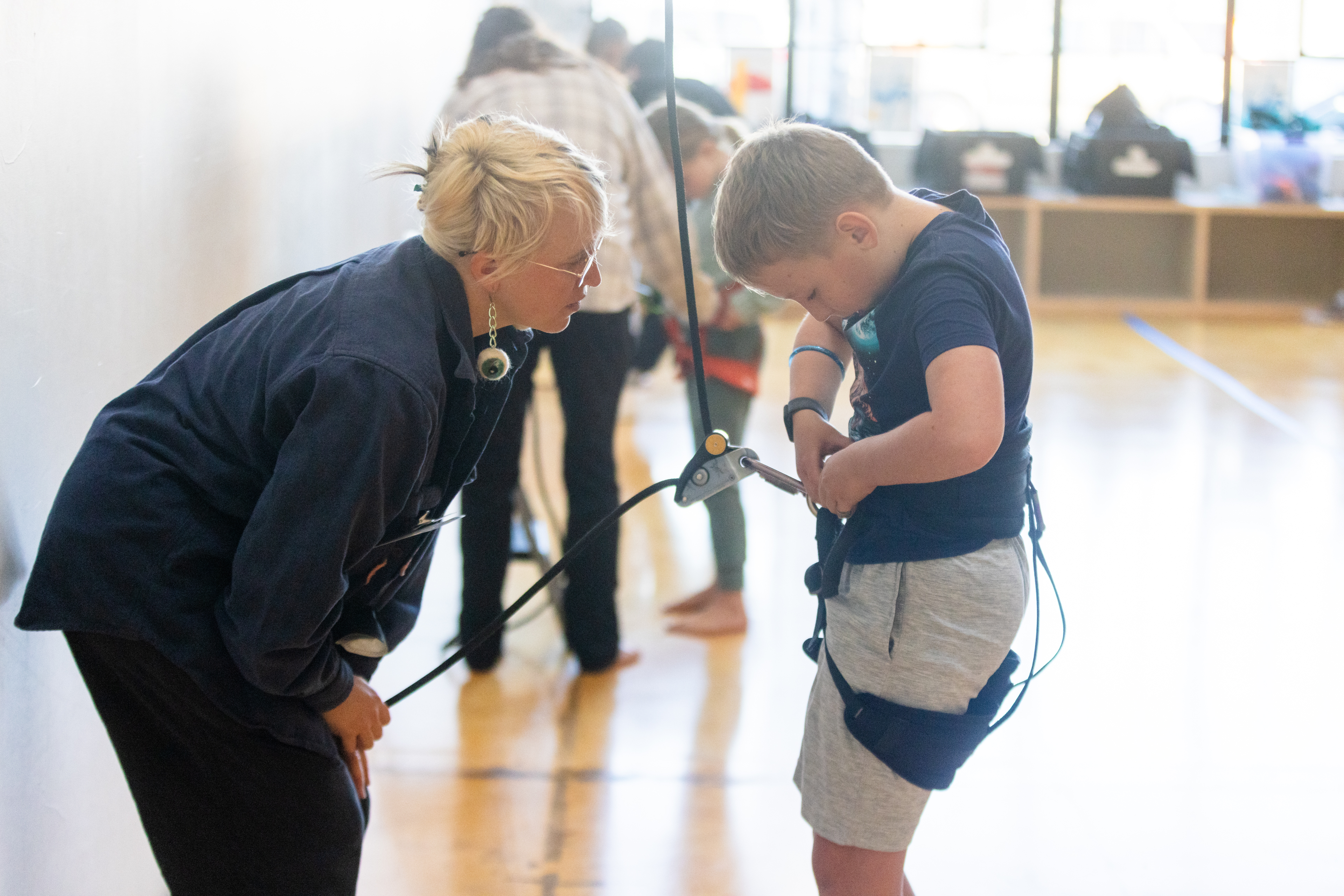 OAKLAND, CA - NOVEMBER 12: Krystal Harfert (left) instructs Elliot Smith how to secure their harness during a flight test vertical dance lesson at the BANDALOOP open house at their studio space in Oakland, Calif. on Nov. 12, 2023. BANDALOOP is a renown vertical dance troupe, that have performed their aerial mid-air performances on international landmarks around the world. (Douglas Zimmerman/Special to the Bay Area News Group)