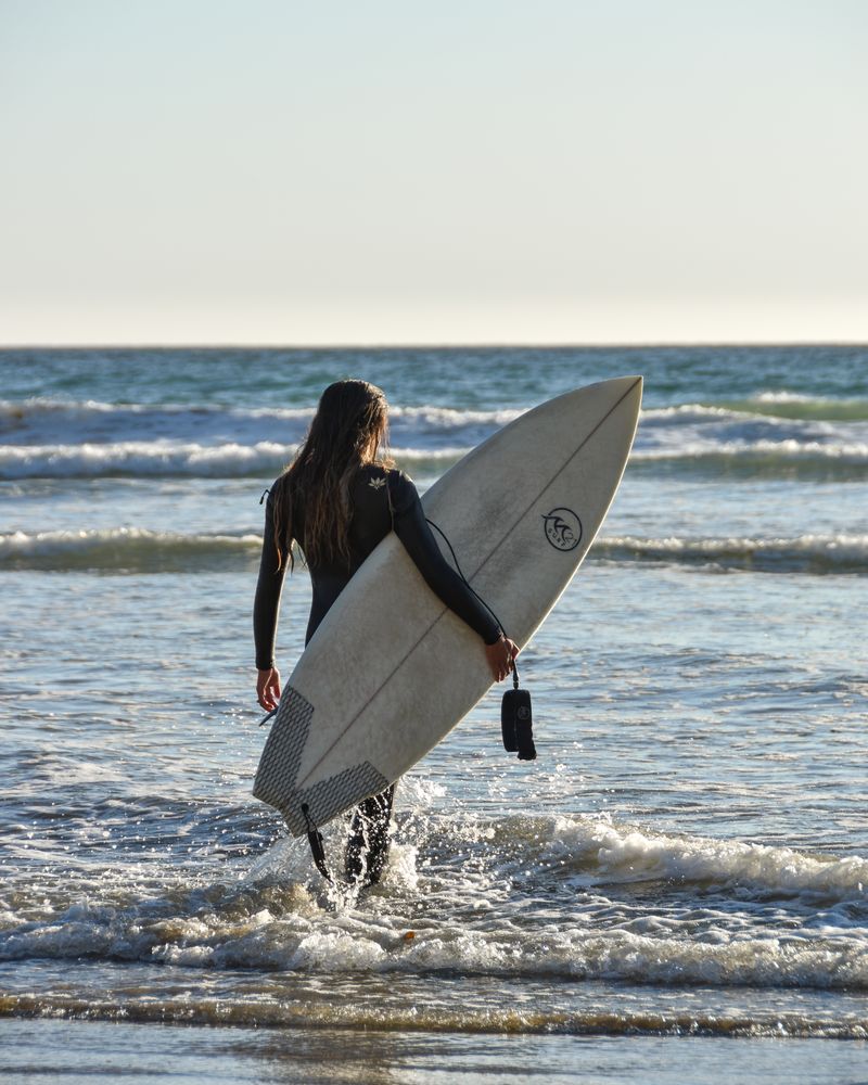 Um surfista está se preparando para remar a praia de Pismo. 
