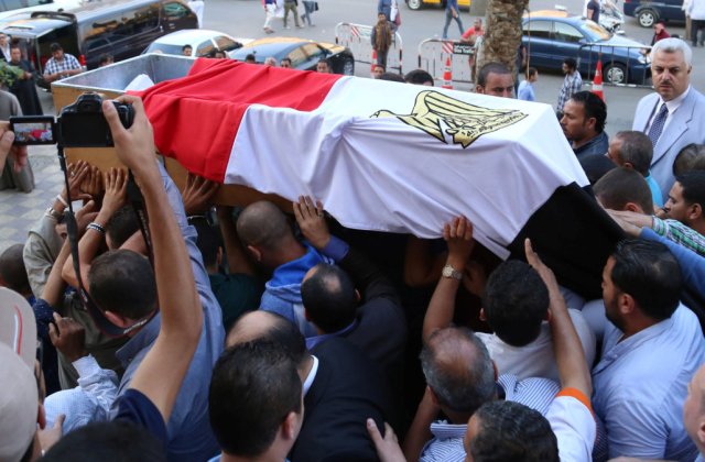 People carry the coffin of Egyptian police officer Ahmed Fayez, who was attacked with other security forces by militants in Egypt's western desert, in El Hosary Mosque outside Cairo