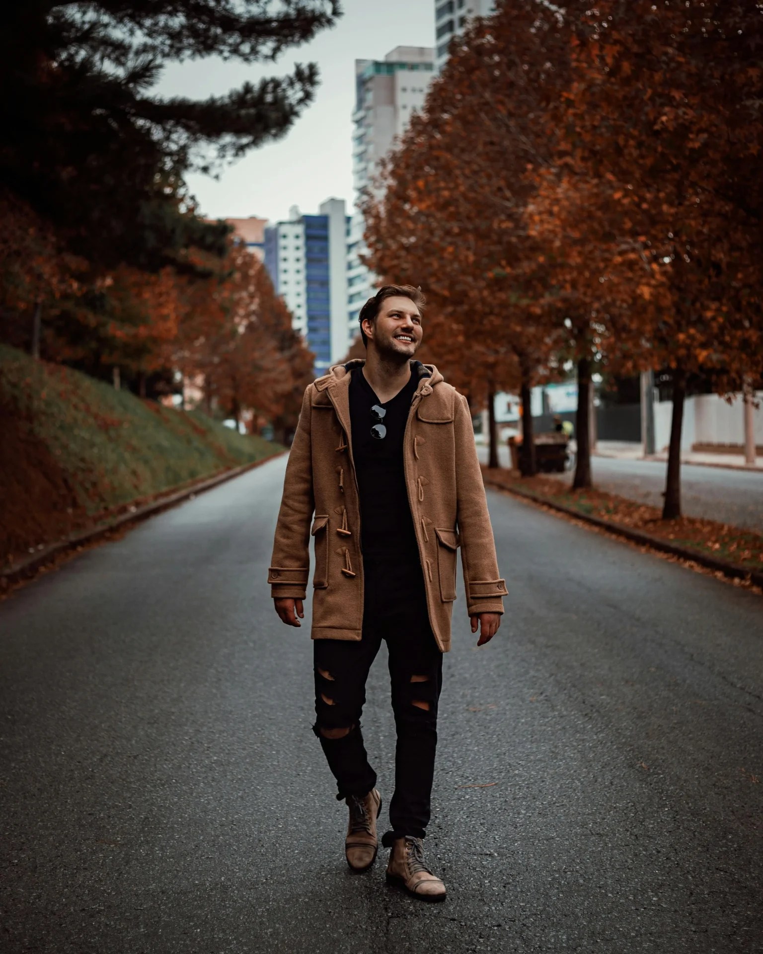 man walking down the road in the fall.