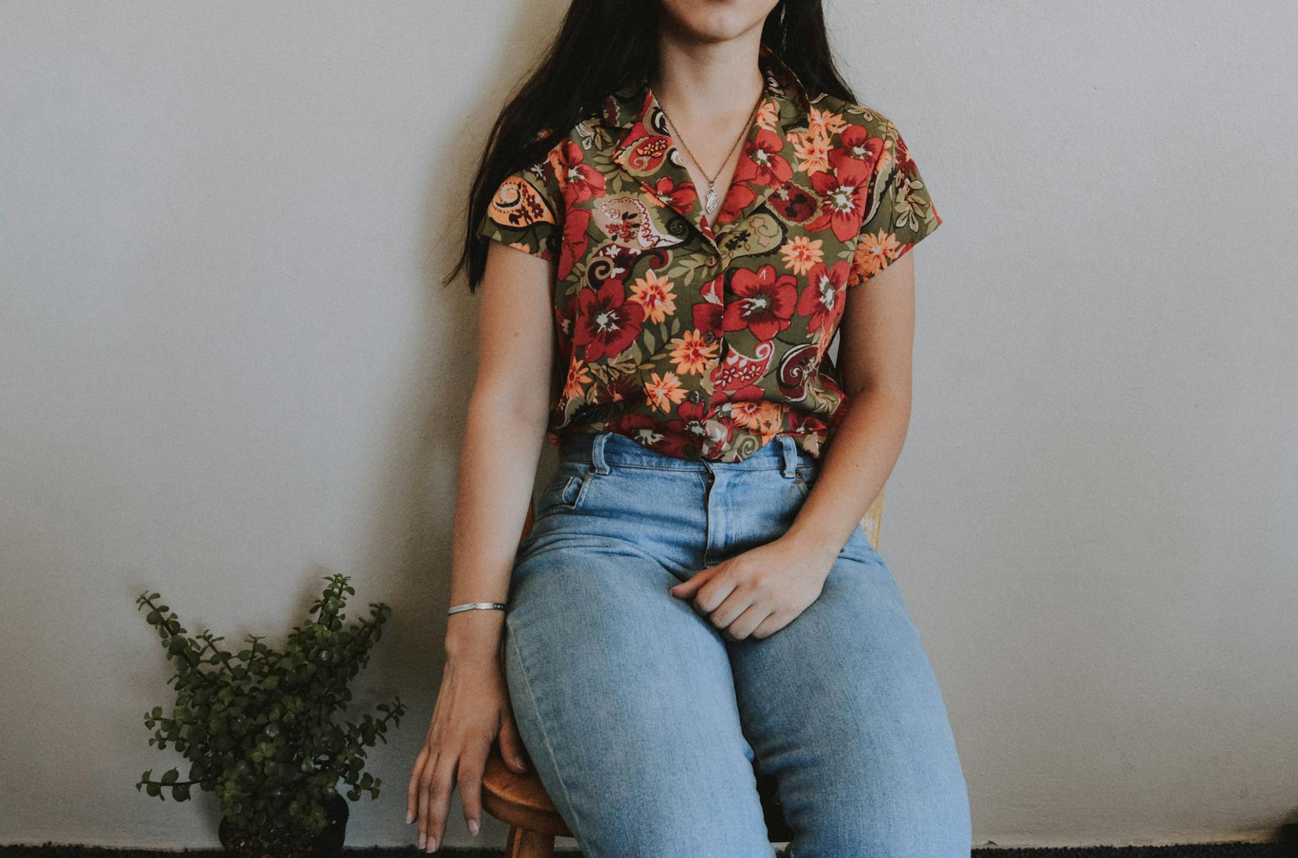 woman sitting on chair beside green plant