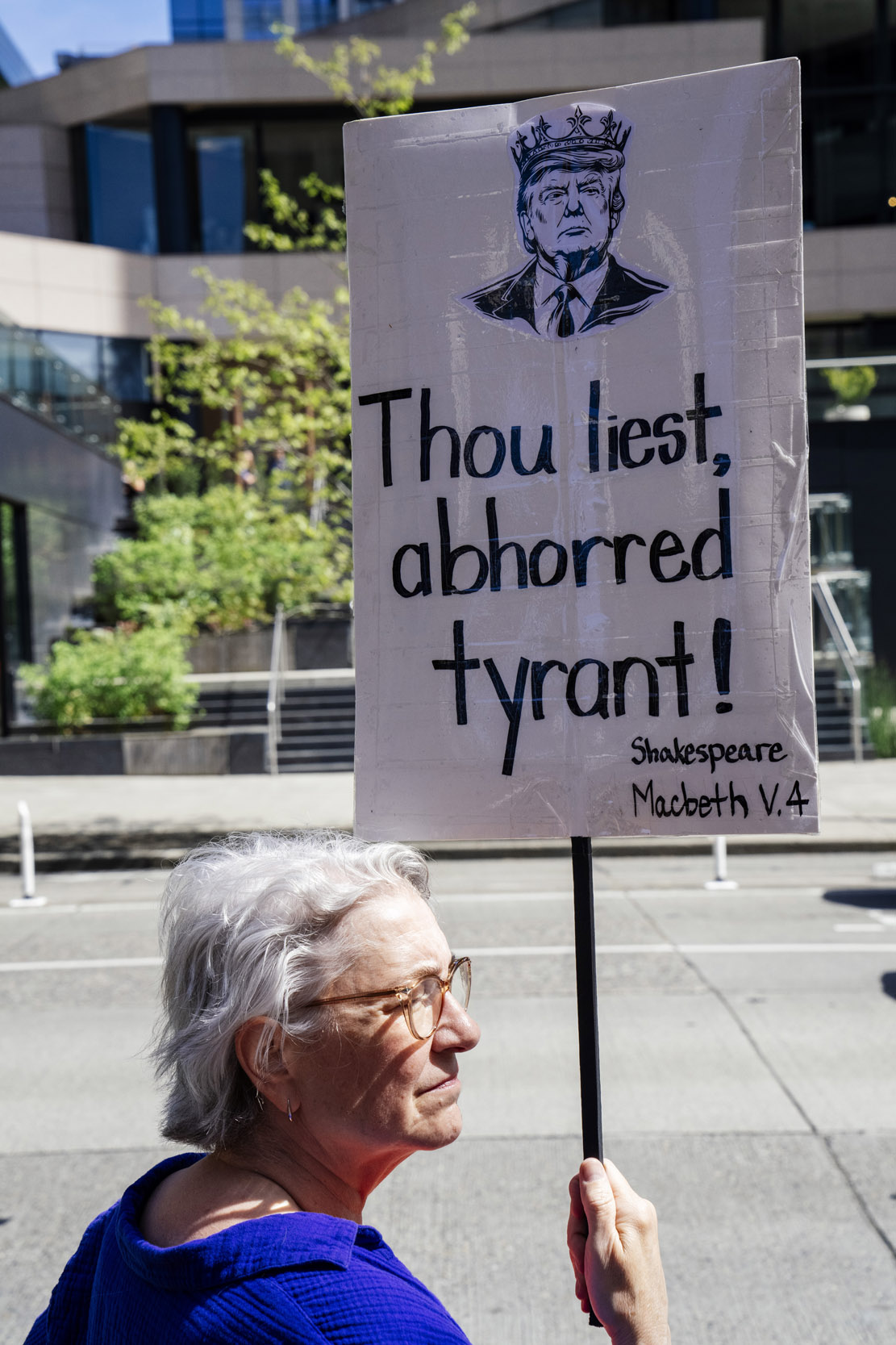 Katherine Klekas, 66, of Seattle, holds a sign reading "Thou liest, abhoored tyrant!" as people rally in support of federal workers outside the Henry M. Jackson Federal Building in Seattle, Washington, USA, on Fri., April 25, 2025. Since the inauguration of President Donald Trump and his appointment of Elon Musk to the Department of Government Efficiency (DOGE) federal workers have faced uncertainty and layoffs around the country.