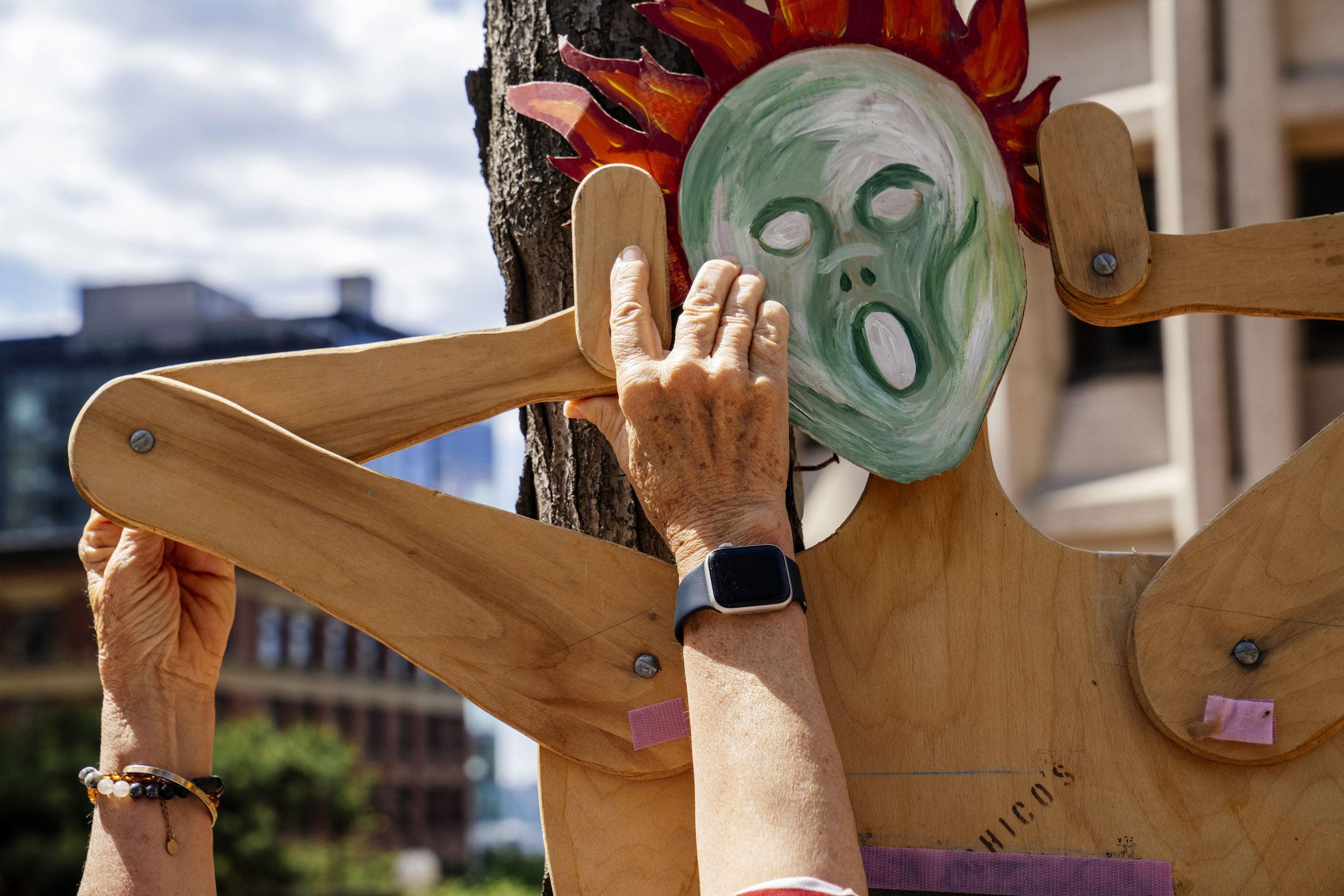 Ginger Montague, 77, of Seattle, puts up a puppet featuring a face that looks like the figure from Edvard Munch's painting "The Scream" as people rally in support of federal workers outside the Henry M. Jackson Federal Building in Seattle, Washington, USA, on Fri., May 2, 2025. Since the inauguration of President Donald Trump and his appointment of Elon Musk to the Department of Government Efficiency (DOGE) federal workers have faced uncertainty and layoffs around the country.