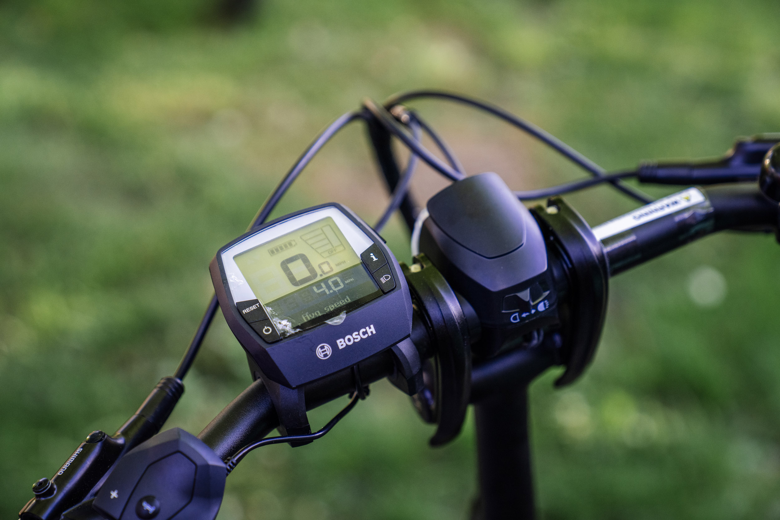An e-bike's pedal assist control is visible on the handlebars while Pedal Forward Shoreline participants take part in an e-bike-focused urban cycling class put on by Cascade Bicycle Club at Ridgecrest Elementary School in Shoreline, Washington, USA, on Wed., May 7, 2025. Pedal Forward Shoreline is a program to give free e-bikes to residents in what has been deemed an “overburdened community” determined to have health, social, and environmental inequities at the south end of Shoreline east of I-5. As part of an effort to reduce driving in the city, the program will give out approximately 100 e-bikes to residents in the neighborhood, prioritizing households with incomes at or below 80% of the King County median income.   (M. Scott Brauer / Cascade PBS)