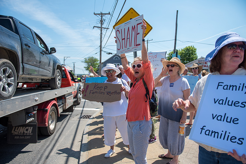 Ralliers cheer as cars drive by to honk in support.