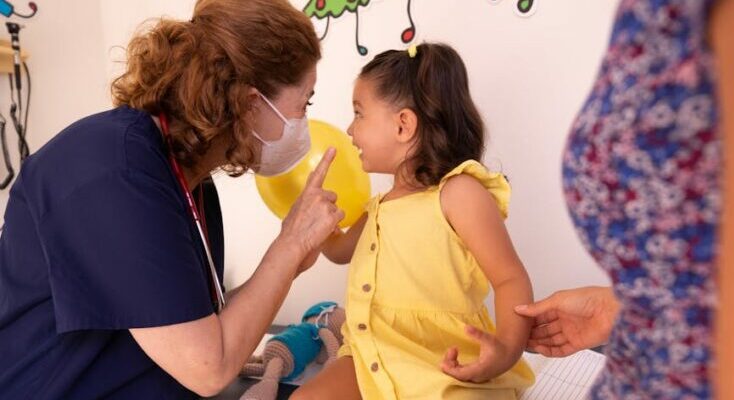 Nurse talking to a little girl at a pediatricians office