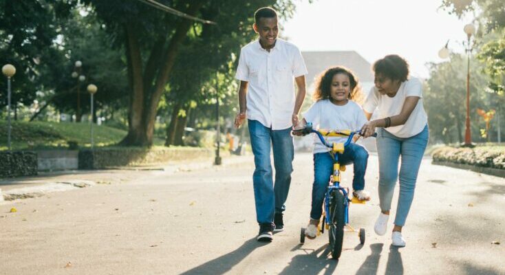 Parents teaching their child how to ride bicycle