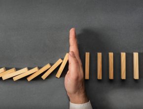 Chain Reaction In Dominoes but a Hand stops it
