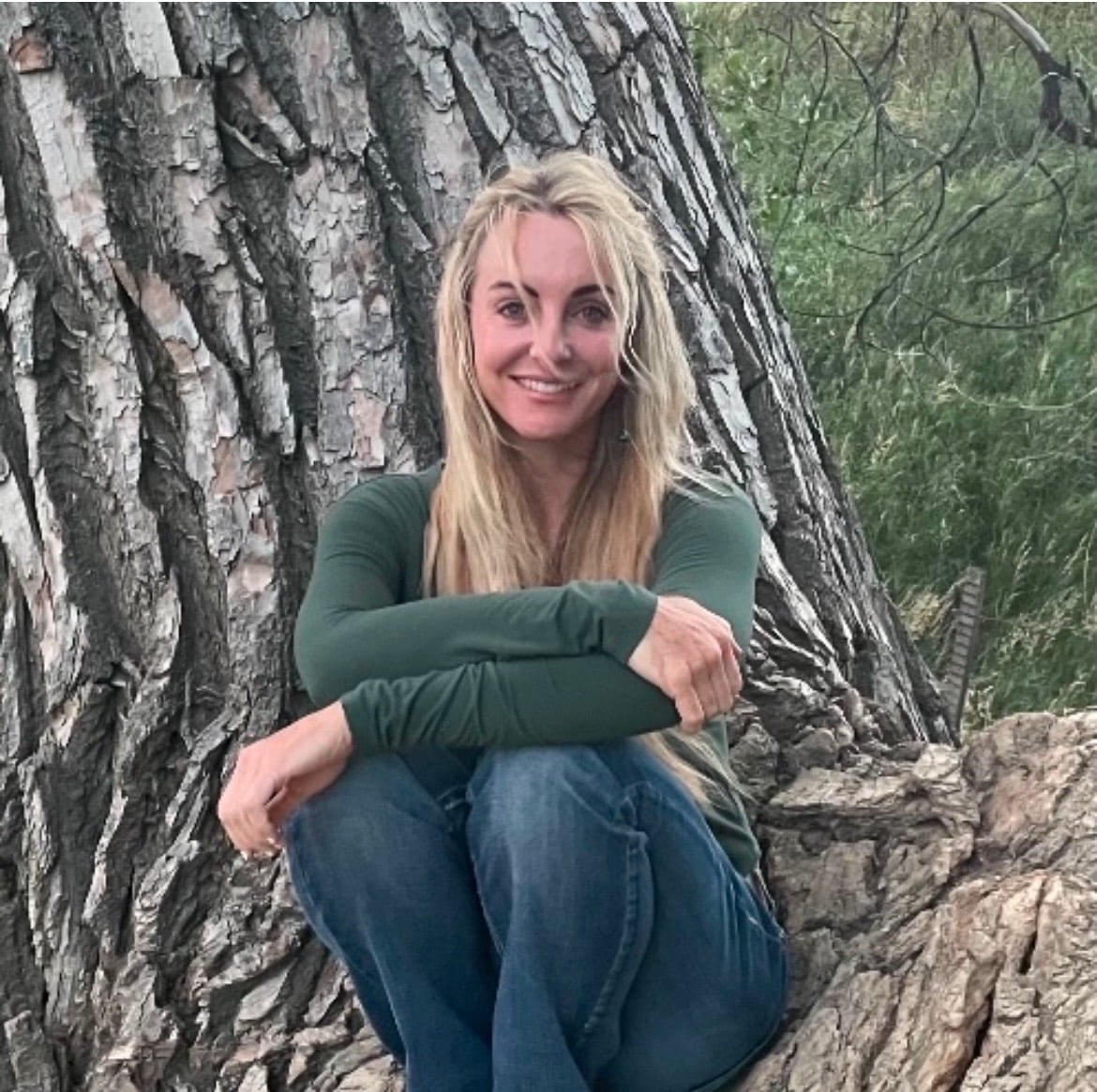 Lisa Chatham sitting in front of a tree