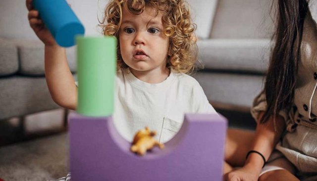 young boy stacking up toys