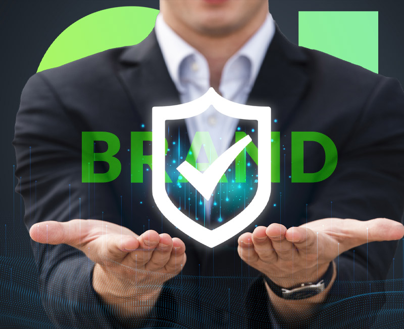 A business professional holding out their hands with a digital shield and checkmark symbol representing brand protection.