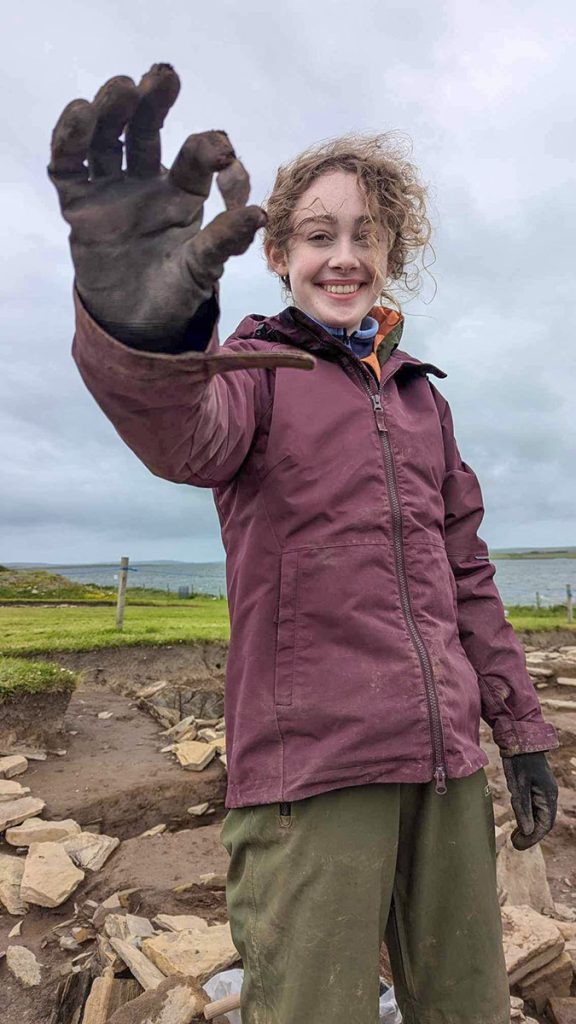 Minna with a flint scraper recovered from the north end of Structure One. (📷 Andy Boyar)
