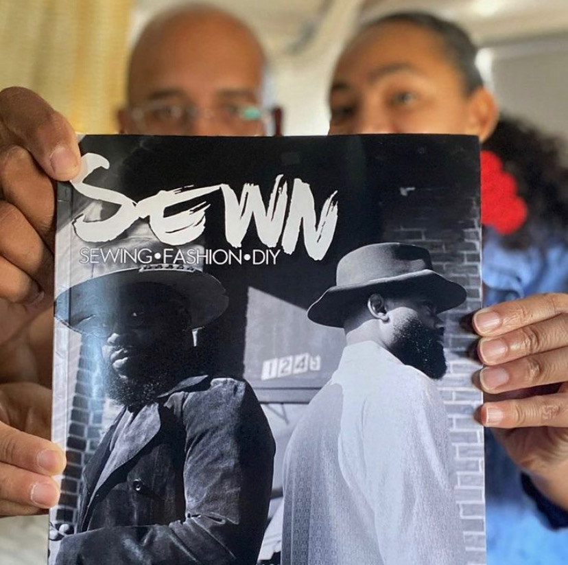 Two black people holding up a copy of SEWN magazine with the No Man Hat Co. owners on the front