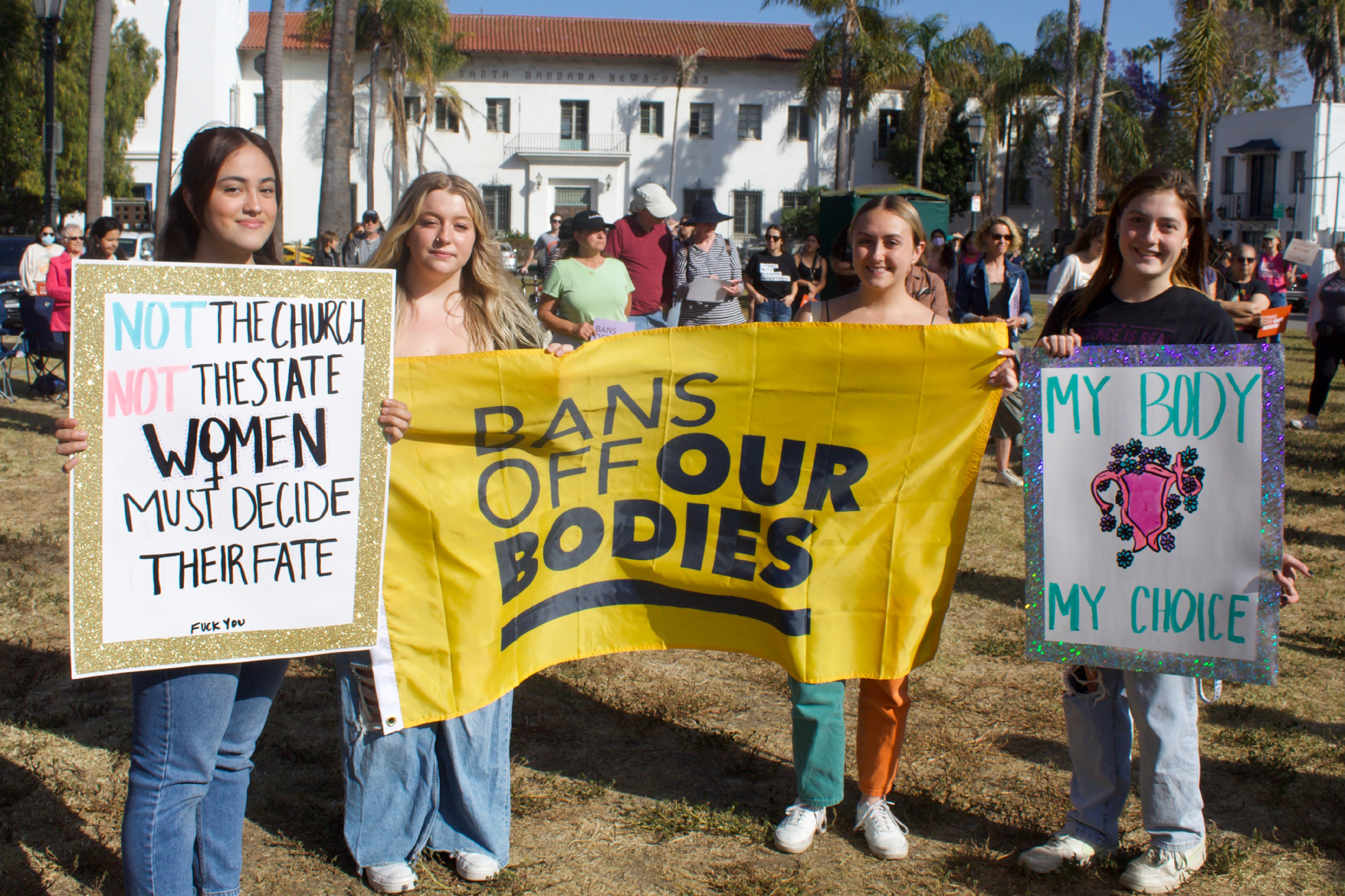 Four participants hold up signs in support of reproductive rights during a rally Tuesday at De la Guerra Plaza in Santa Barbara.