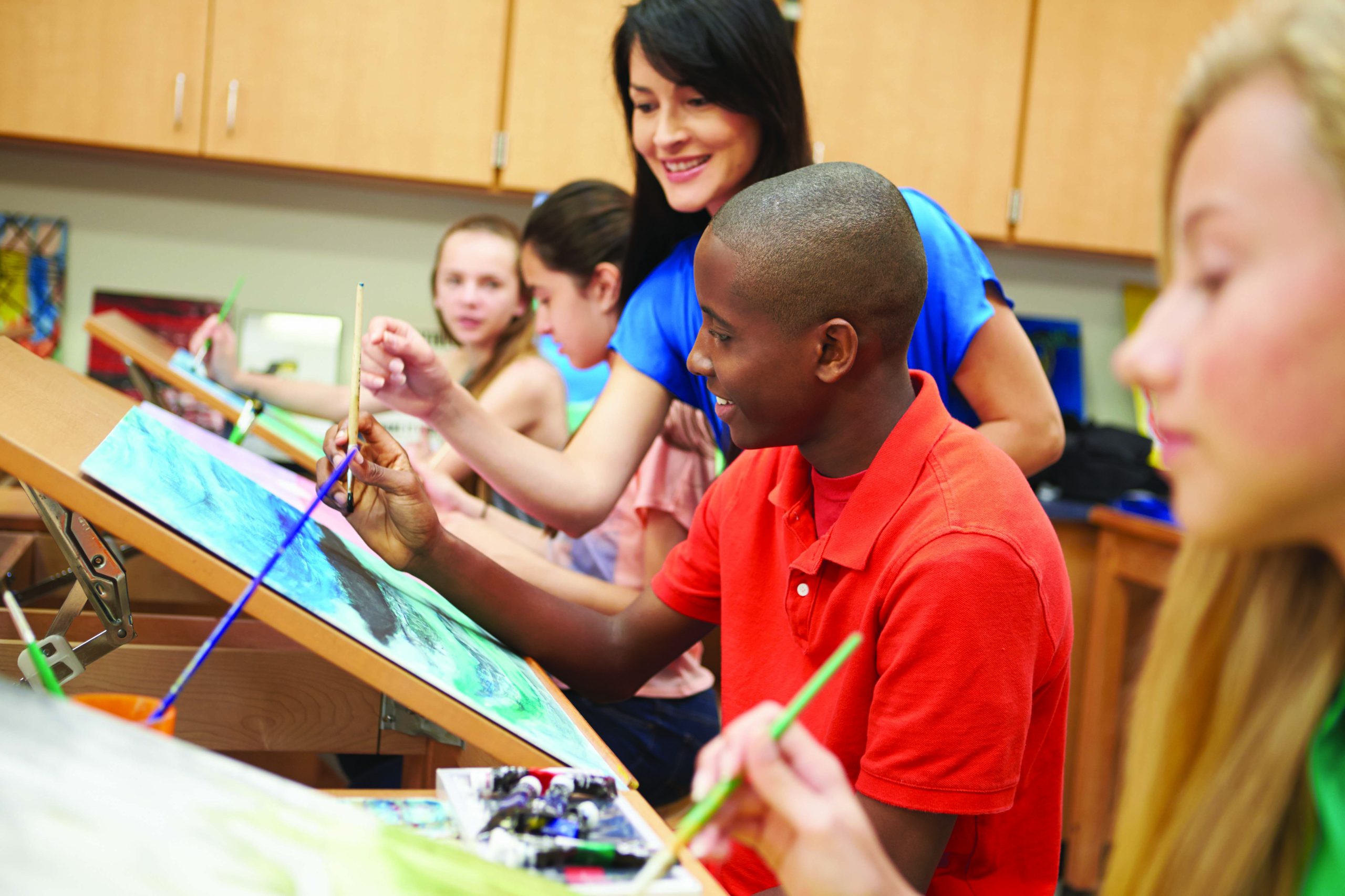 Male Pupil In High School Art Class With Teacher