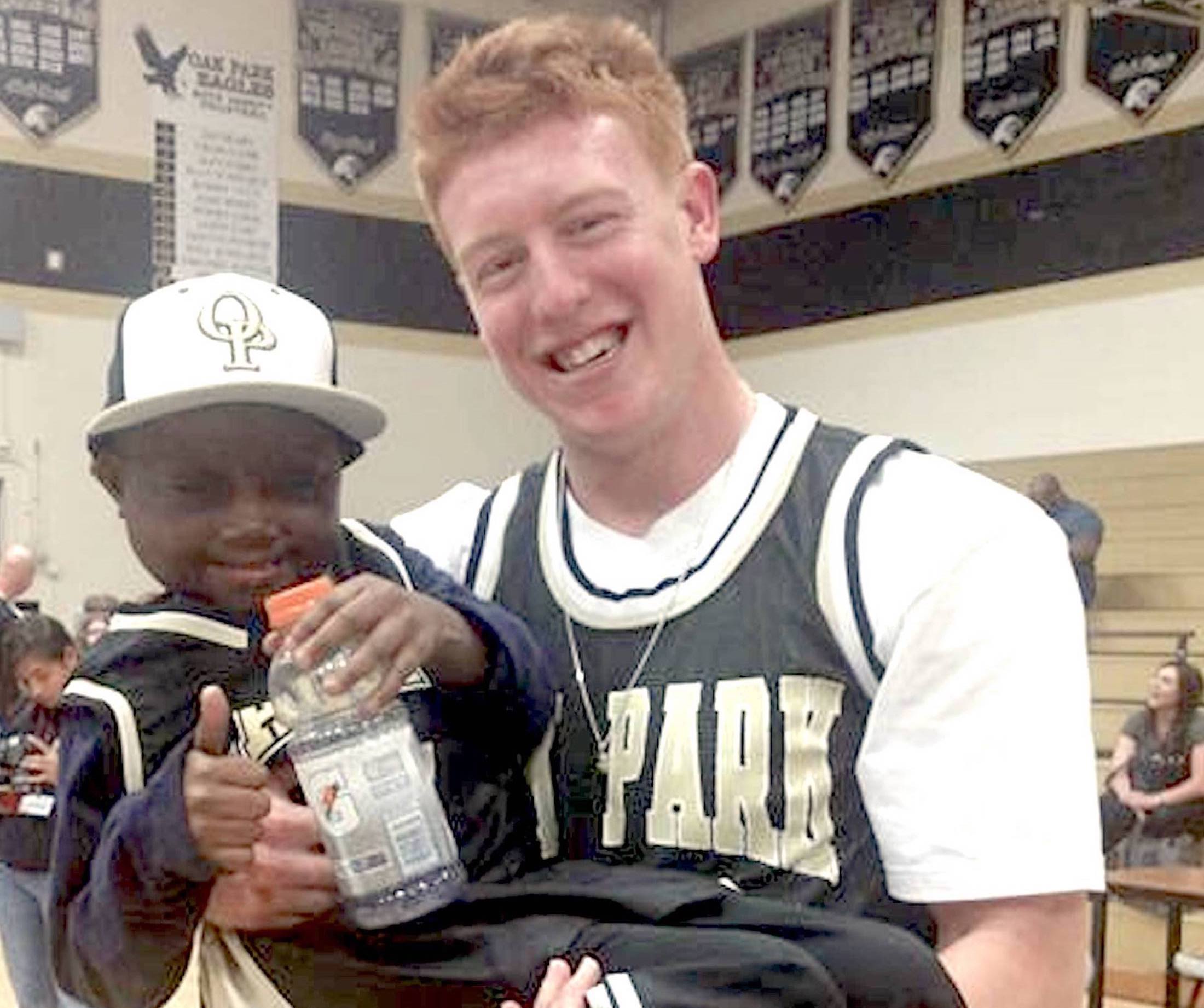 J.D. Slajchert holds Luc Bodden after one of his basketball games during his 2014 senior season at Oak Park High School.