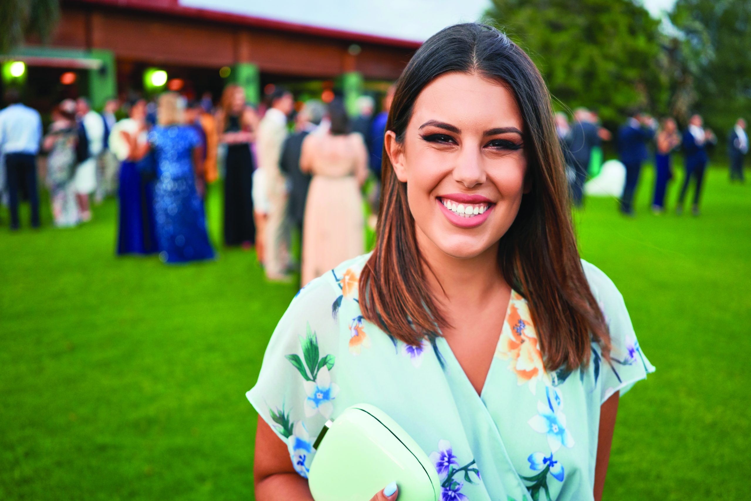 Woman guest smiling at wedding reception.